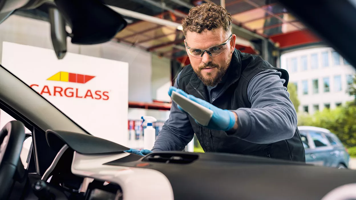 Carglass Monteur reinigt Windschutzscheibe